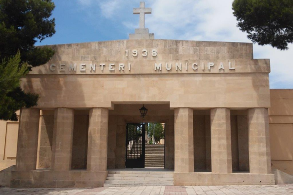 https://www.cementerio.info/ . La fotografía muestra la entrada principal del Cementerio Municipal de Palma de Mallorca. Se trata de una construcción sólida y simétrica con un estilo arquitectónico minimalista y funcional. La entrada está compuesta por una serie de pilares rectangulares robustos que sostienen un entablamento sobre el cual se encuentra inscrito “CEMENTERI MUNICIPAL 1938” en letras en relieve, indicando el nombre y la fecha de inauguración o remodelación del cementerio. En el centro, hay una gran puerta de rejas de metal que permite ver parcialmente el interior del cementerio. Sobre la entrada, coronando la estructura, hay una cruz cristiana, que se alza como símbolo de la función sagrada del lugar. La entrada invoca un sentido de tranquilidad y respeto, características adecuadas para un espacio dedicado al descanso final. La presencia de árboles en ambos lados añade un toque de serenidad y vida al diseño austero del cementerio. La luz del sol baña la fachada, creando un ambiente acogedor y pacífico. 